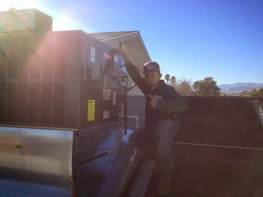 HVAC technician performing HVAC Inspection on a rooftop unit in Greenfield